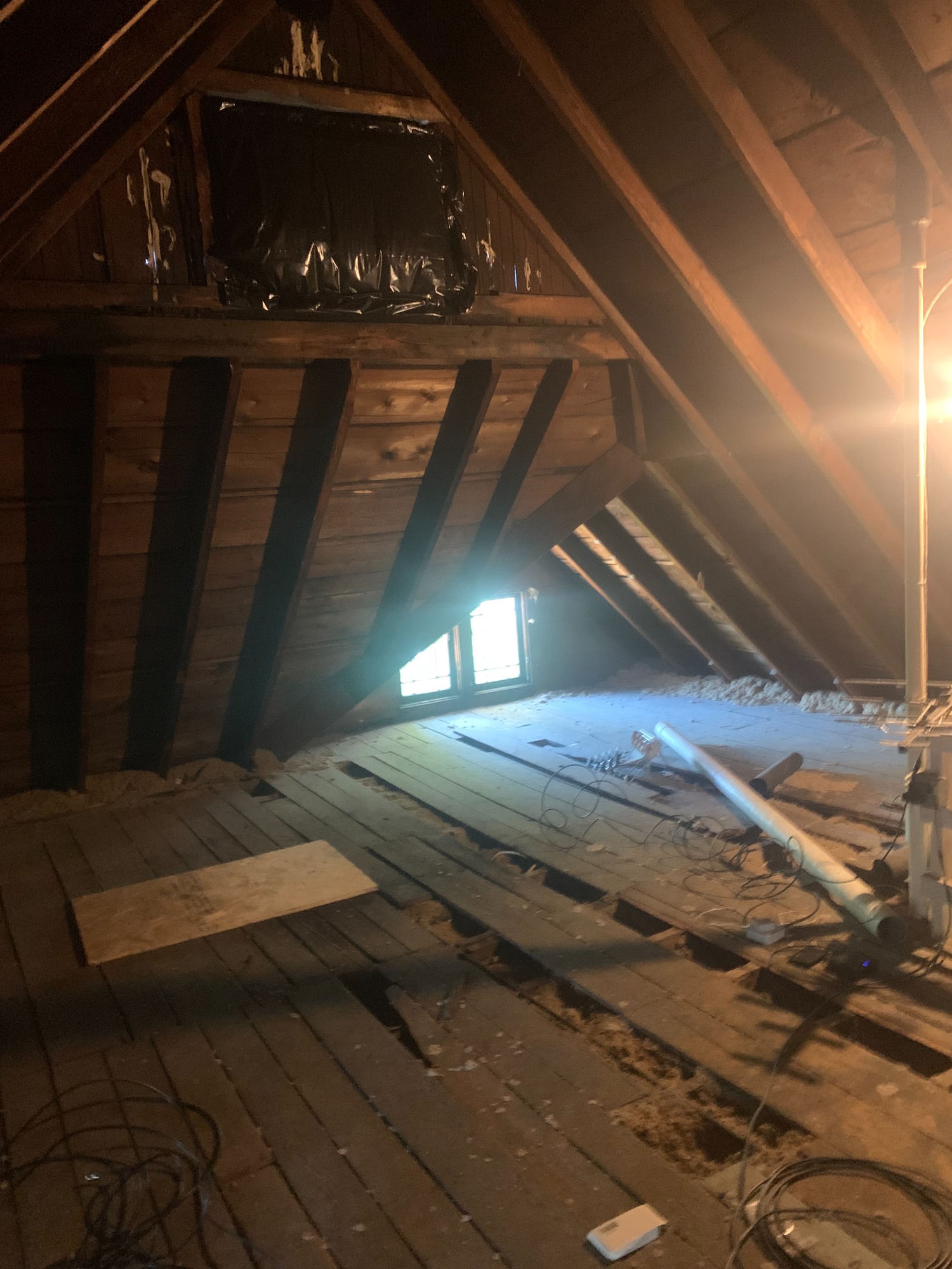 Bare attic with exposed rafters before conversion
