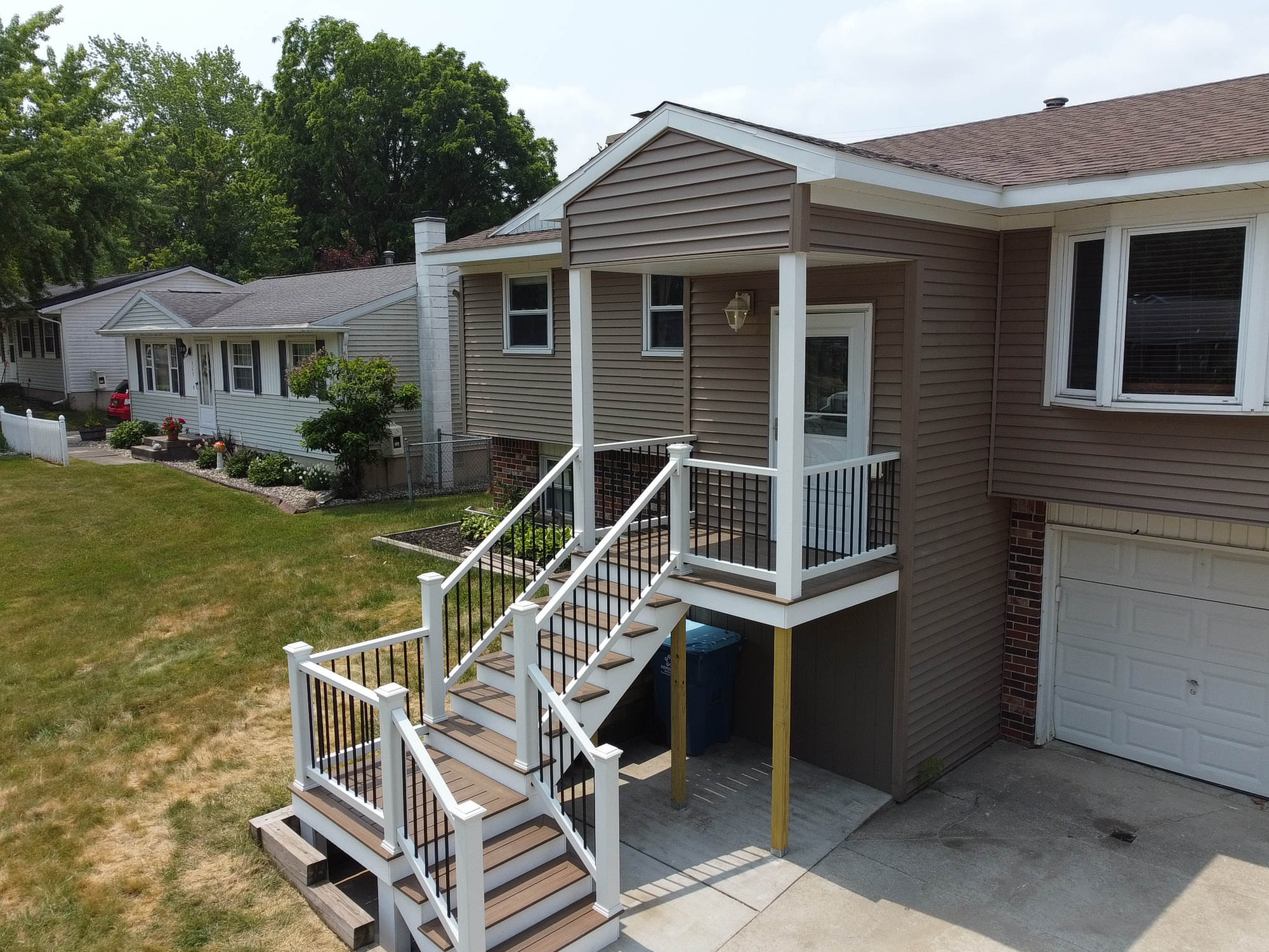Composite deck rebuild with white railings by Nelson Remodeling