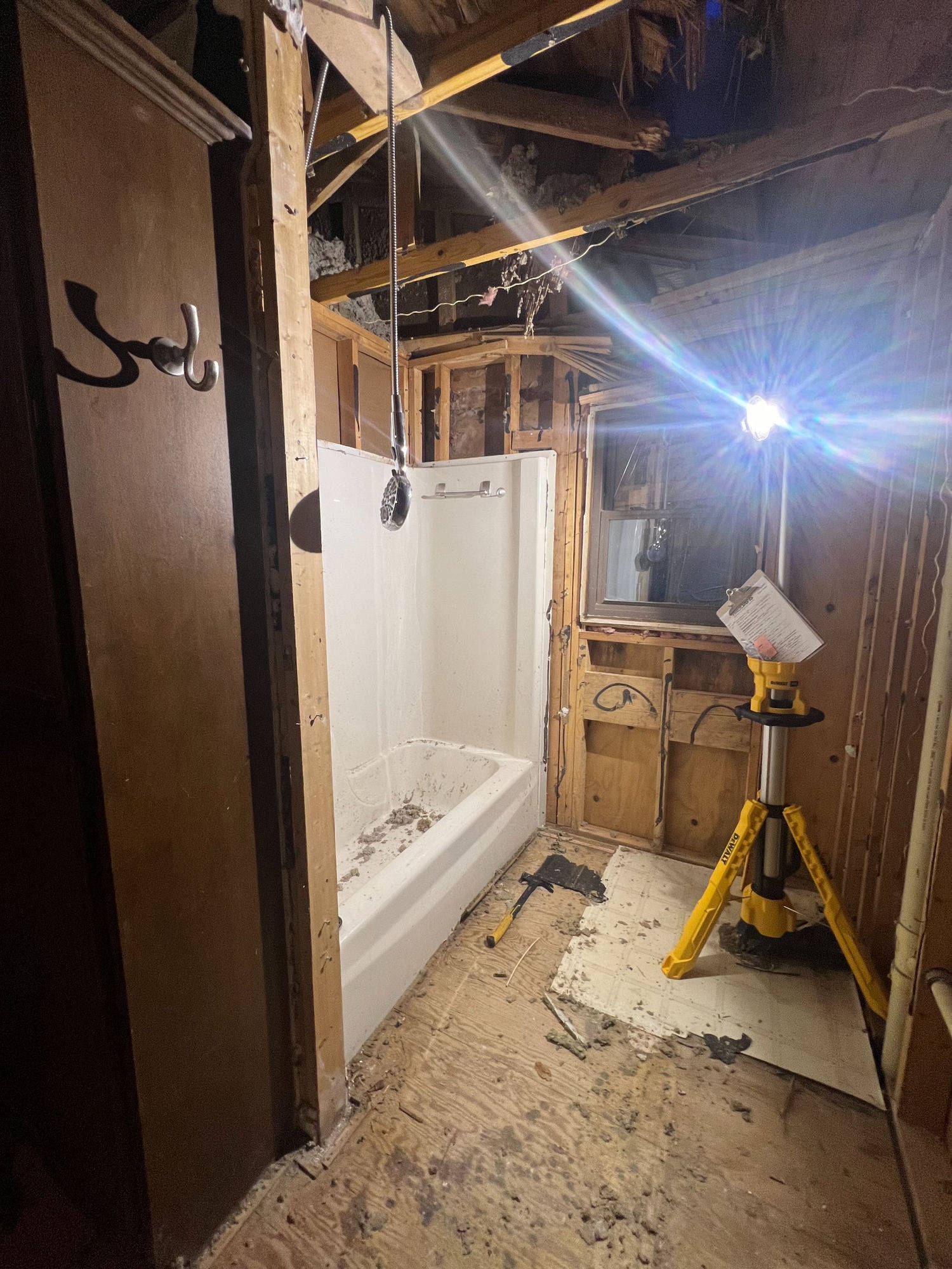Bathroom gutted to studs after storm damage — before remodel